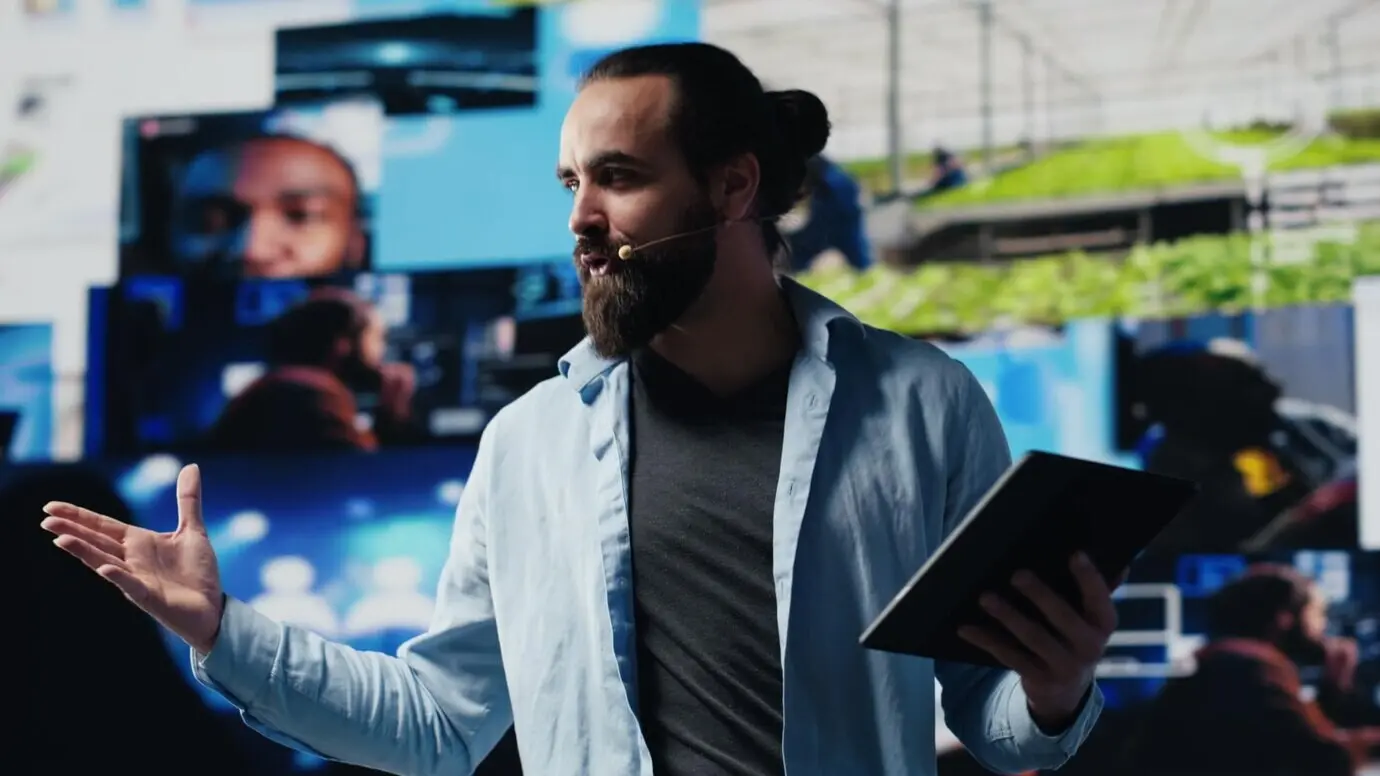 Мужчина, крутой ИТ-эксперт, ведёт конференцию в прямом эфире с микрофоном, который не нужно держать в руках.