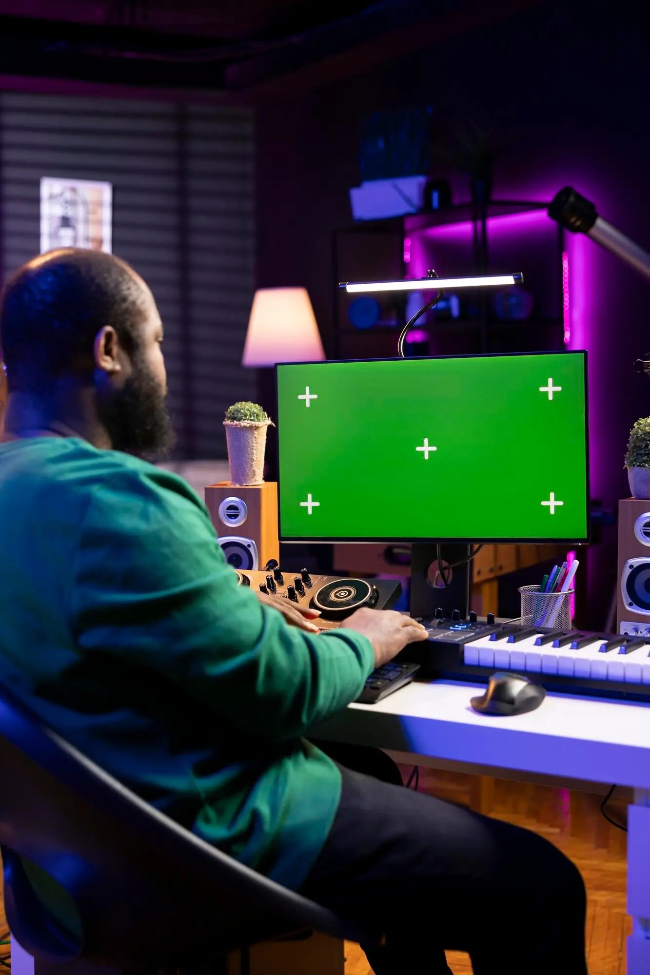 Аудиоинженер, создающий новую музыку, на дисплее с зелёным экраном.
